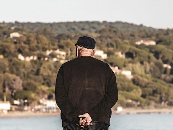 Un adulto mayor mirando el mar