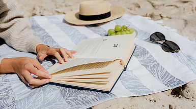 Persona lee un libro en la playa