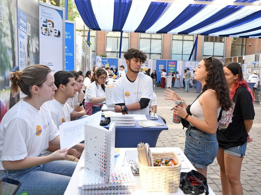 Estudiantes atendiendo dudas de postulantes a la universidad.