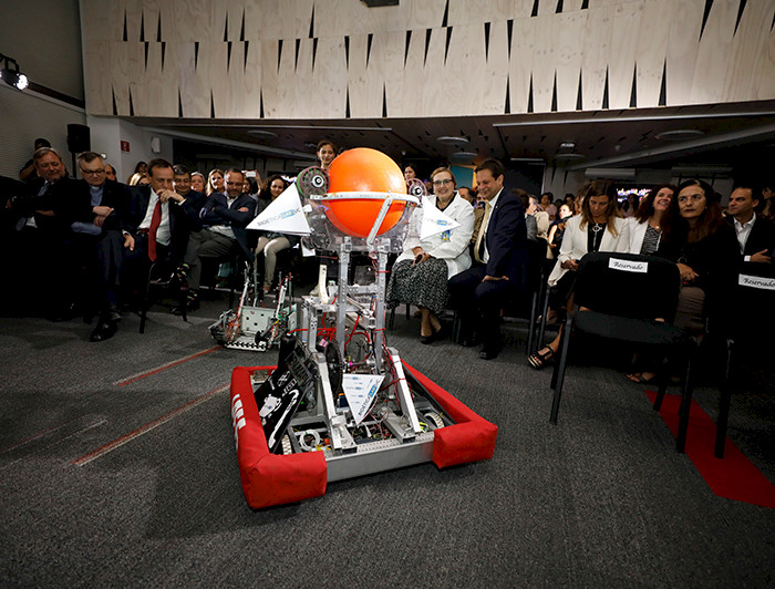 Imagen de un robot y personas de la UC mirándolo