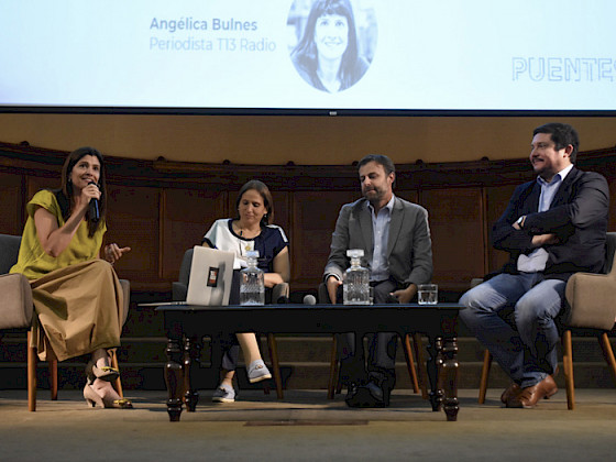 La foto muestra el escenario con el panel en el que participaron el alcalde de Puente Alto, Germán Codina, la alcaldesa de Peñalolén, Carolina Leitao y el alcalde de Macul, Gonzalo Montoya. Ellos además de la moderadora Angélica Bulnes, periodista de Tele13 Radio.