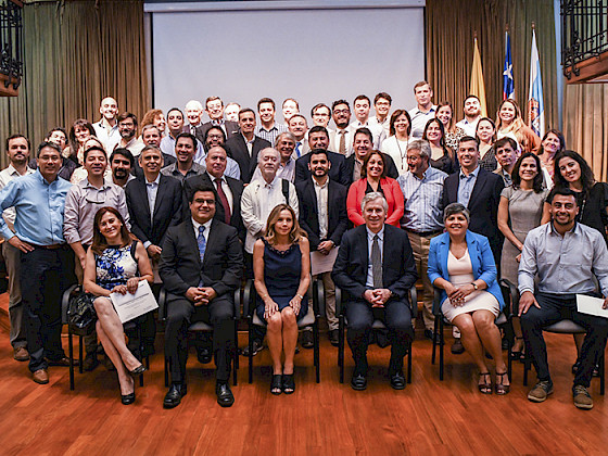 Foto muestra a todos los titulados en el escenario, junto a autoridades de la universidad.