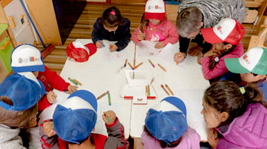 Imagen de niños sentados a la mesa realizando una actividad educativa