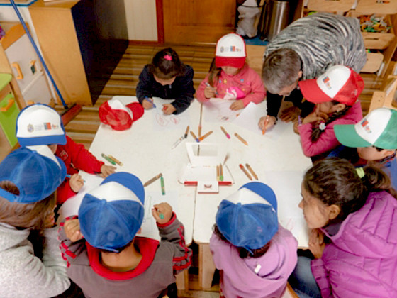 Imagen de niños sentados a la mesa realizando una actividad educativa