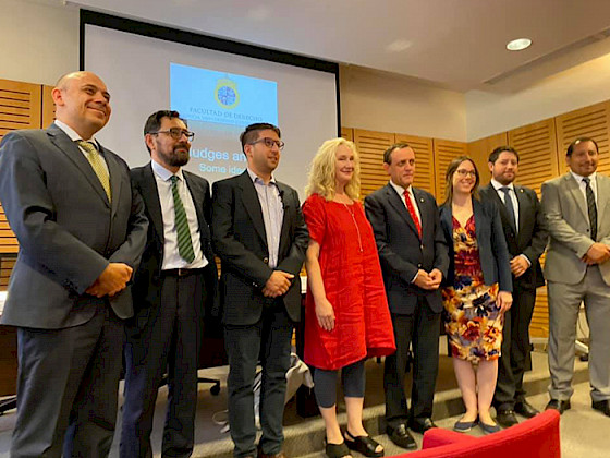 En la imagen se ve a académicos junto a la expositora principal, Valentine Goddard