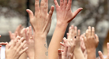Mujeres levantando las manos.
