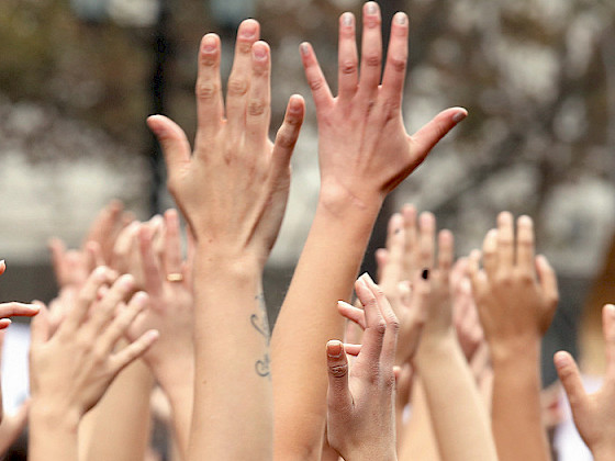 Mujeres levantando las manos.