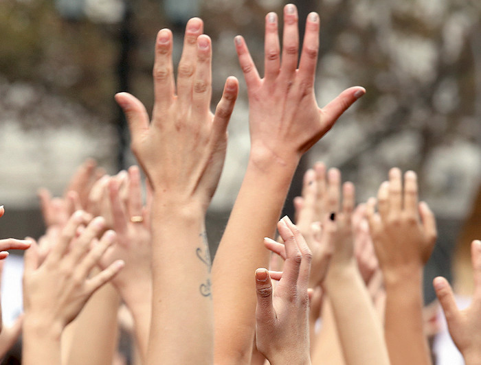 Mujeres levantando las manos.