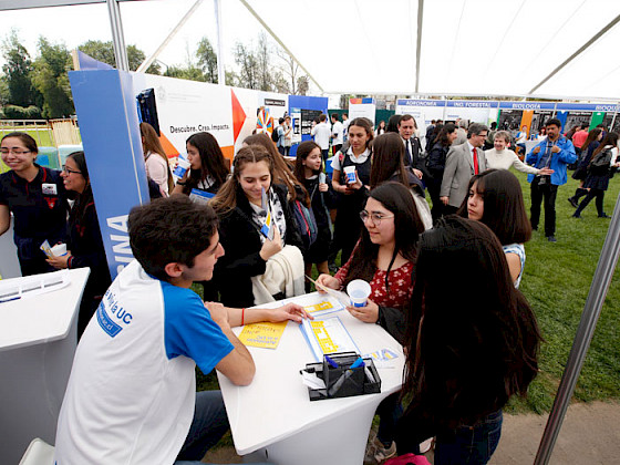 Foto de estudiantes haciendo consultas por carreras en feria.