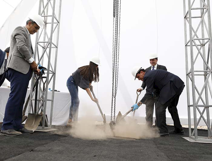 imagen de dos personas poniendo primera piedra de edificio