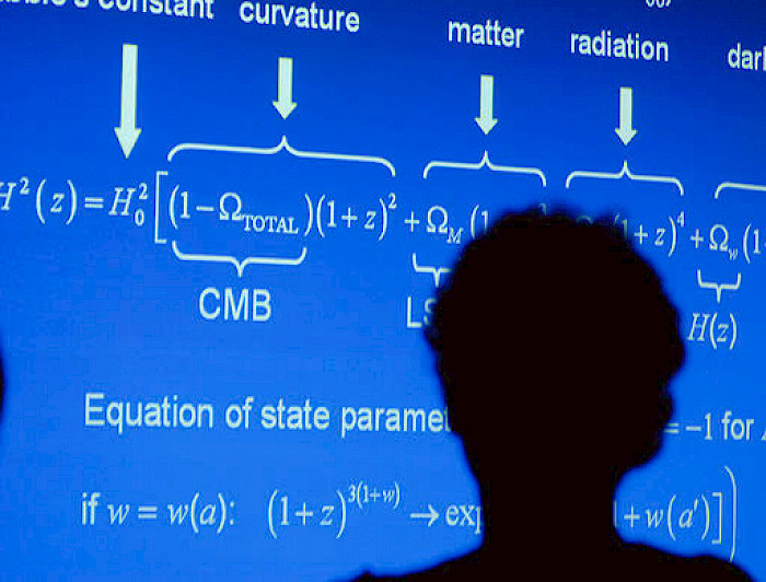 Imagen de personas frente a pizarra con cálculos matemáticos