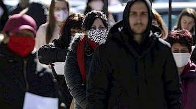 Imagen de personas haciendo fila y usando protectores buco nasales para enfrentar la pandemia