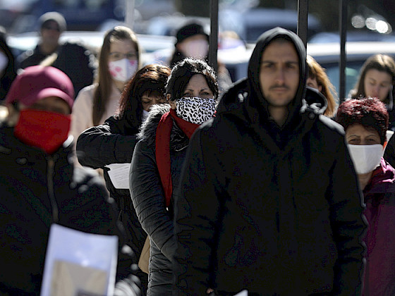 Imagen de personas haciendo fila y usando protectores buco nasales para enfrentar la pandemia