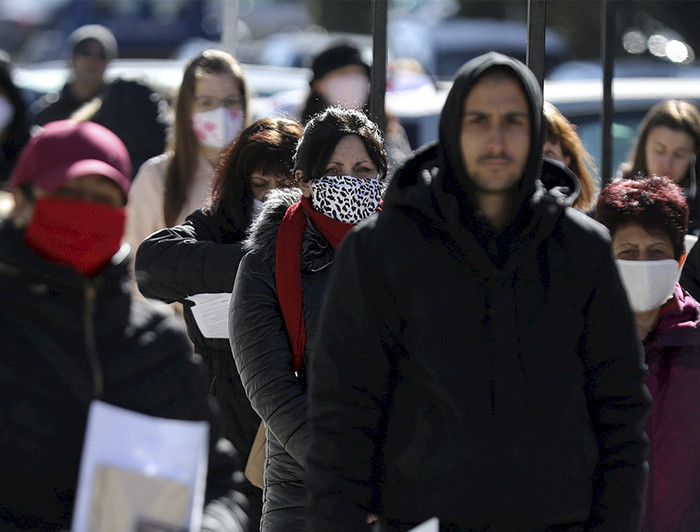 Imagen de personas haciendo fila y usando protectores buco nasales para enfrentar la pandemia