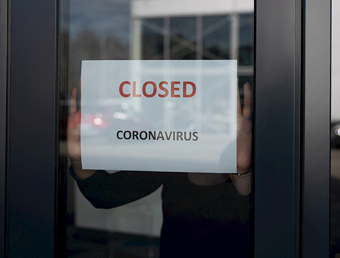 Imagen de puerta de negocio donde se lee cartel "closed"