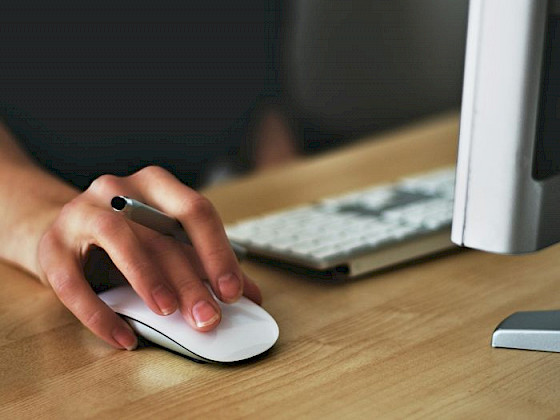 Una mano sobre un mouse inalámbrico