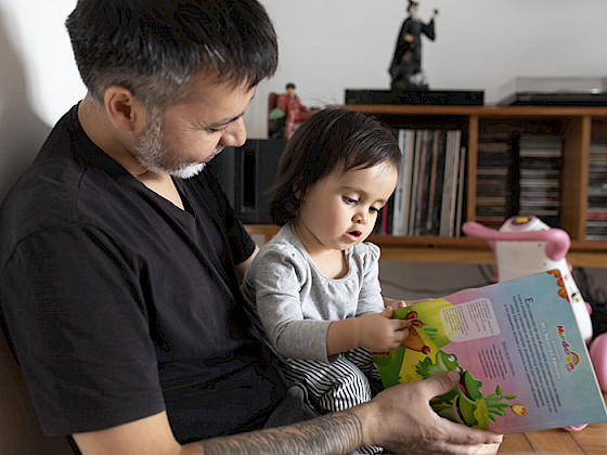Padre con hija revisan libro infantil