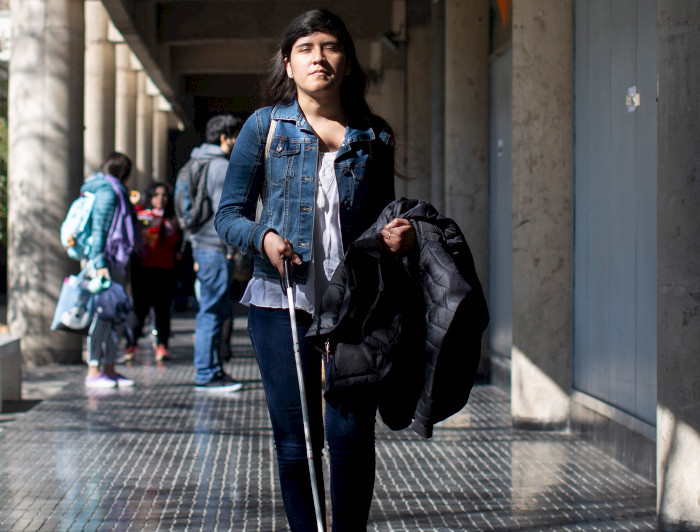 Foto de una alumna con discapacidad visual usando el piso podotáctil de San Joaquín
