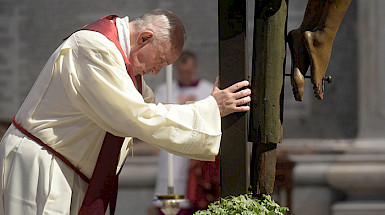 Foto del papa Francisco rezando a los pies de un crucifijo