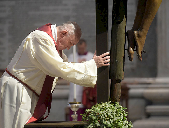 Foto del papa Francisco rezando a los pies de un crucifijo