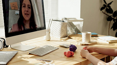 imagen de computador con profesora enseñando por medio de la pantalla a un niño