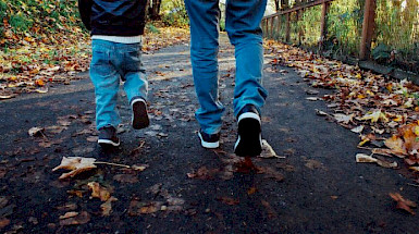 Dos menores de edad caminan en un bosque otoñal, en contexto a la información sobre el estudio de estudios psíquicos en la primera infancia, abordado en un seminario de la Escuela de Psicología y MIDAP.