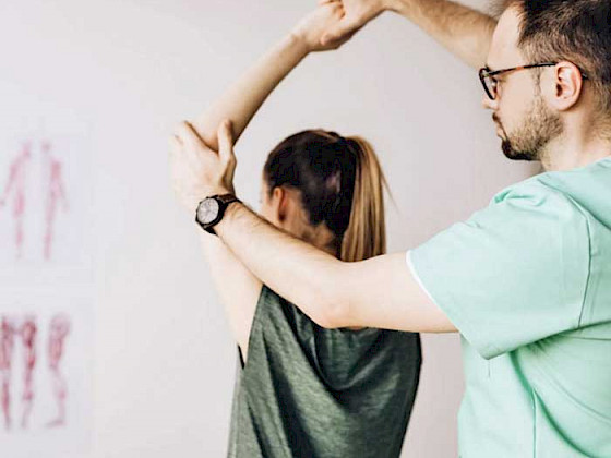 persona sentada con las piernas cruzadas sobre su cama con el computador apoyado en las piernas