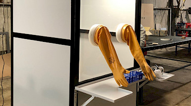 Image: Closed screening booth with built-in yellow gauntlet gloves.