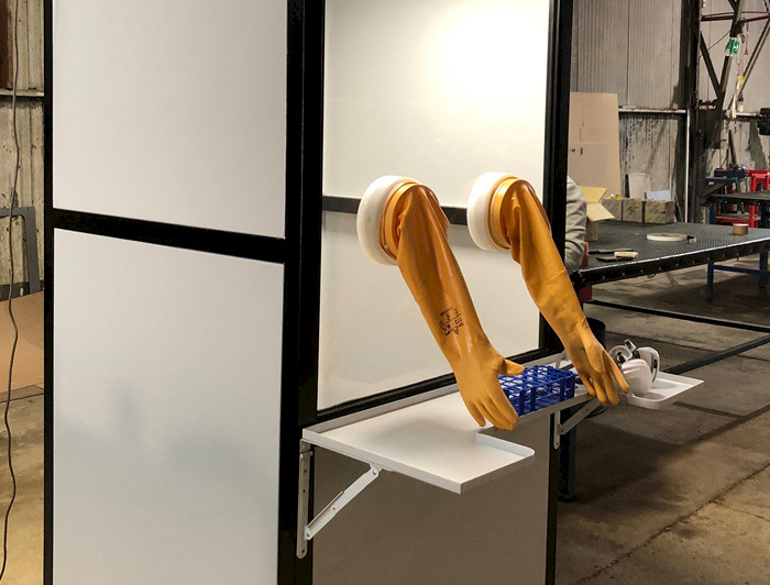 Image: Closed screening booth with built-in yellow gauntlet gloves.