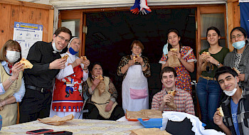 Personas en el comedor social comiendo empanadas