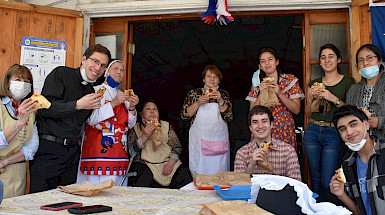 Personas en el comedor social comiendo empanadas