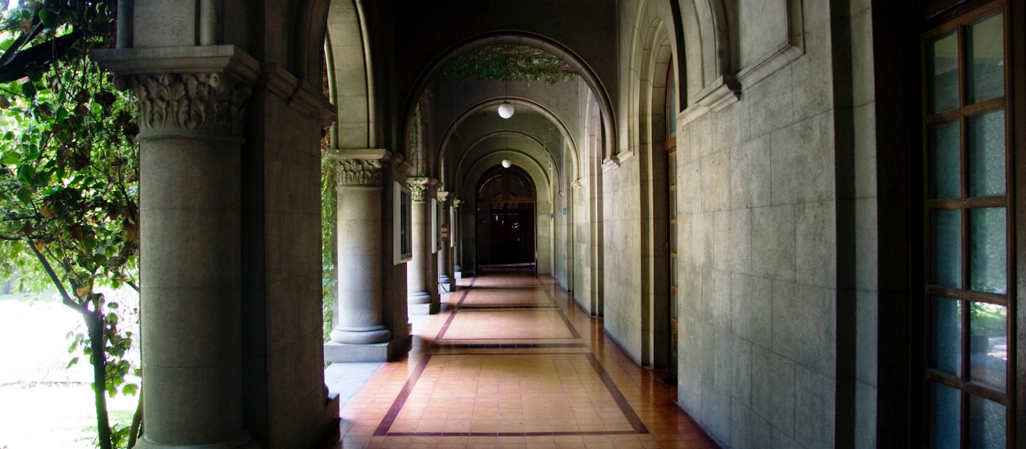 Pasillo interior de Campus Oriente con grandes columnas y arcadas.