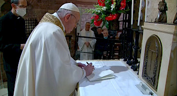 Papa vestido de blanco firmando un papel