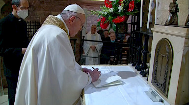 Papa vestido de blanco firmando un papel