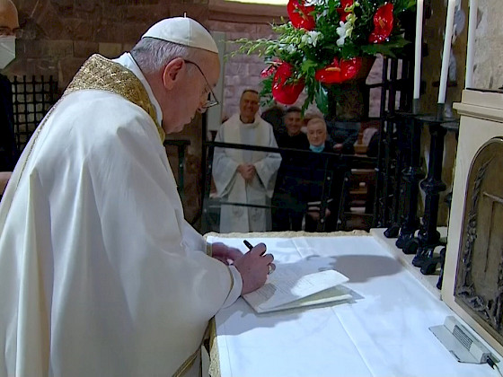Papa vestido de blanco firmando un papel