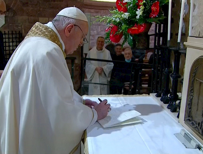 Papa vestido de blanco firmando un papel 