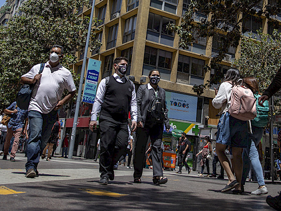 Personas caminando por el centro De Santiago usando mascarillas.
