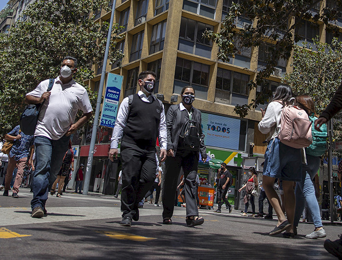 Personas caminando por el centro De Santiago usando mascarillas.
