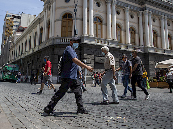 Imagen de personas caminando en la calle con mascarilla