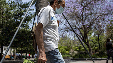 Hombre adulto mayor camina por el centro De Santiago con mascarilla.