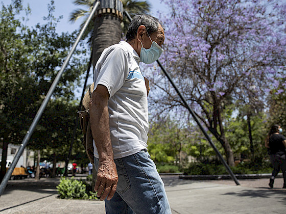 Hombre adulto mayor camina por el centro De Santiago con mascarilla.