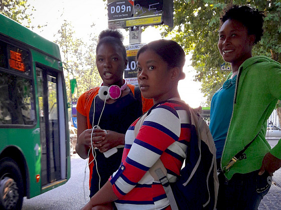 Group of migrant women waiting for a bus.