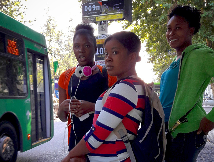 Group of migrant women waiting for a bus.