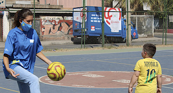 Foto de una misionera jugando a la pelota con un niño