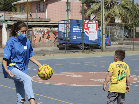 Foto de una misionera jugando a la pelota con un niño