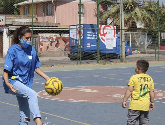 Foto de una misionera jugando a la pelota con un niño 