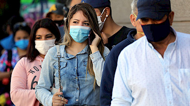 a group of people wearing face masks are standing in line