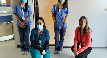 Cuatro mujeres, trabajadoras sociales, usando mascarillas durante la pandemia de coronavirus y su labor de acompañamiento en tratamientos clínicos.
