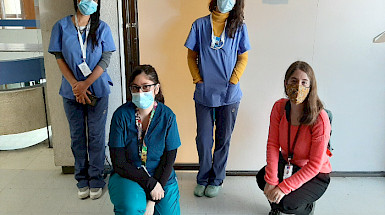 Cuatro mujeres, trabajadoras sociales, usando mascarillas durante la pandemia de coronavirus y su labor de acompañamiento en tratamientos clínicos.