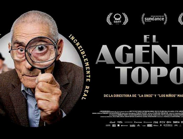 Afiche oficial película El Agente Topo. Primer plano de hombre con una lupa